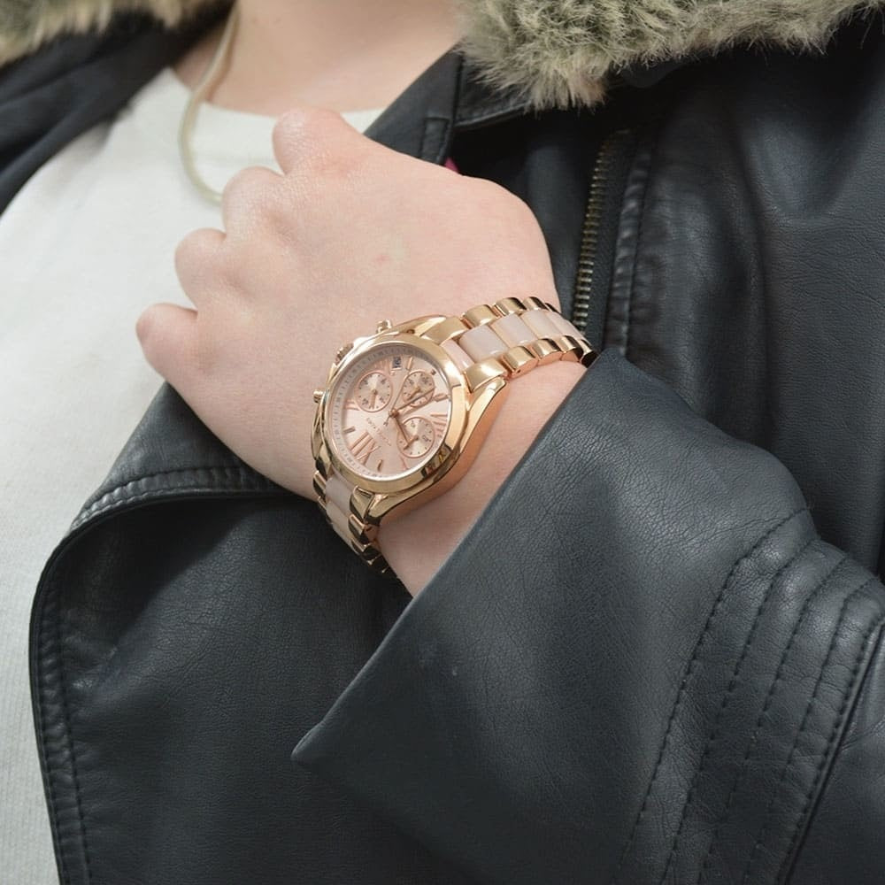 Rose gold watch on a wrist with a black leather jacket