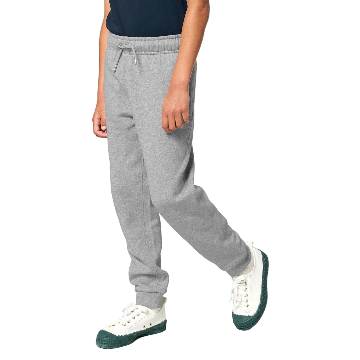 Person wearing grey sweatpants and white sneakers on a plain background