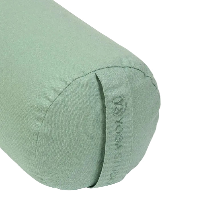 Green yoga bolster with 'Yoga Studio' branding on a light gray background