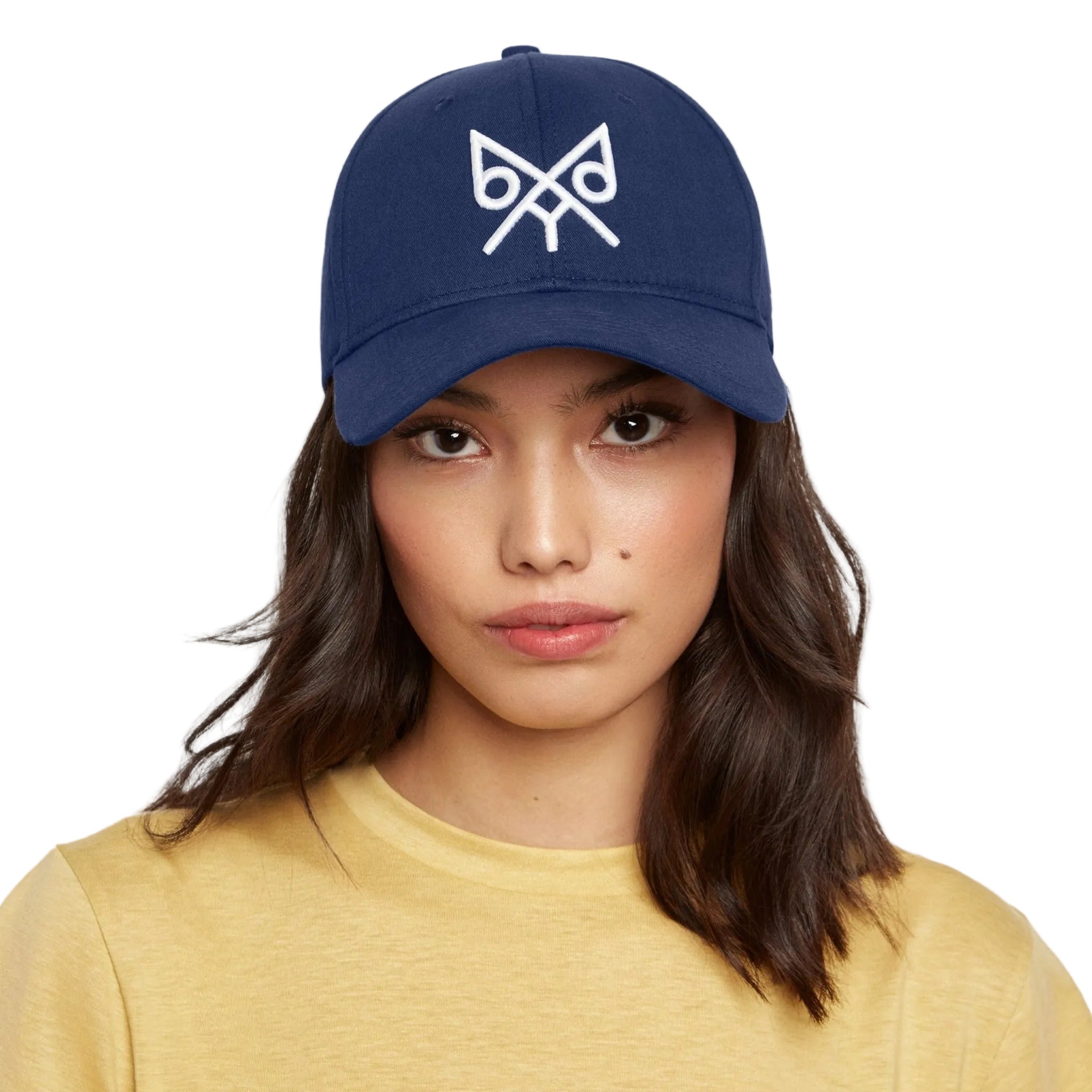 Woman wearing a navy blue cap with a white logo on a white background 