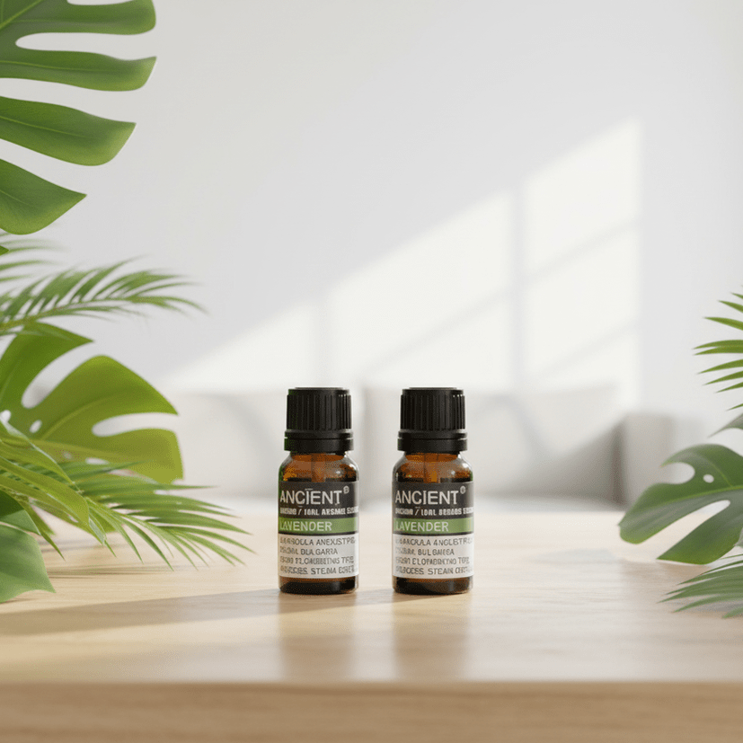 Two bottles of organic essential oil on a wooden surface with green plants in the background.