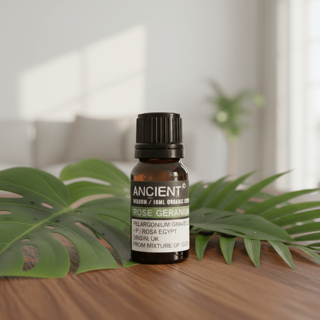 Bottle of 'Ancient Wisdom' organic essential oil with palm leaves on a wooden surface