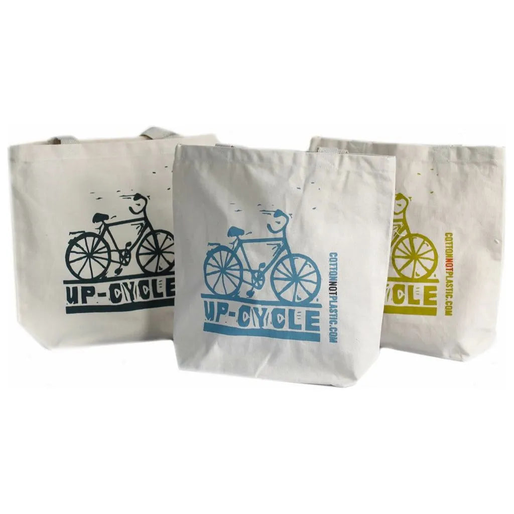Three tote bags with bicycle designs and 'Up-Cycle' text on a white background