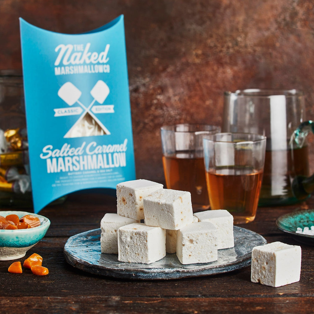 Salted caramel marshmallows on a plate with a 'The Naked Marshmallow' packaging in the background.