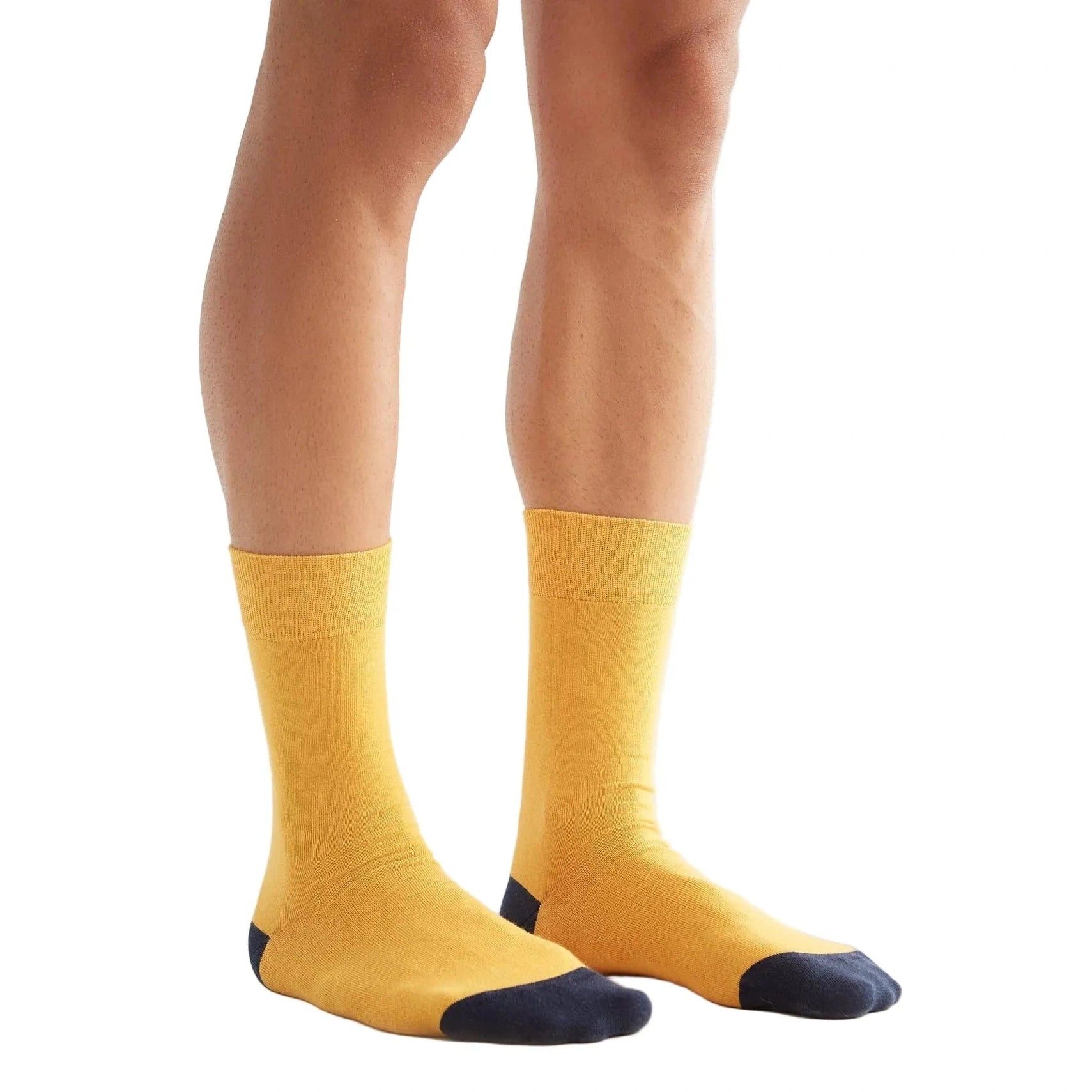 Yellow socks with black toes and cuffs worn by a person on a white background