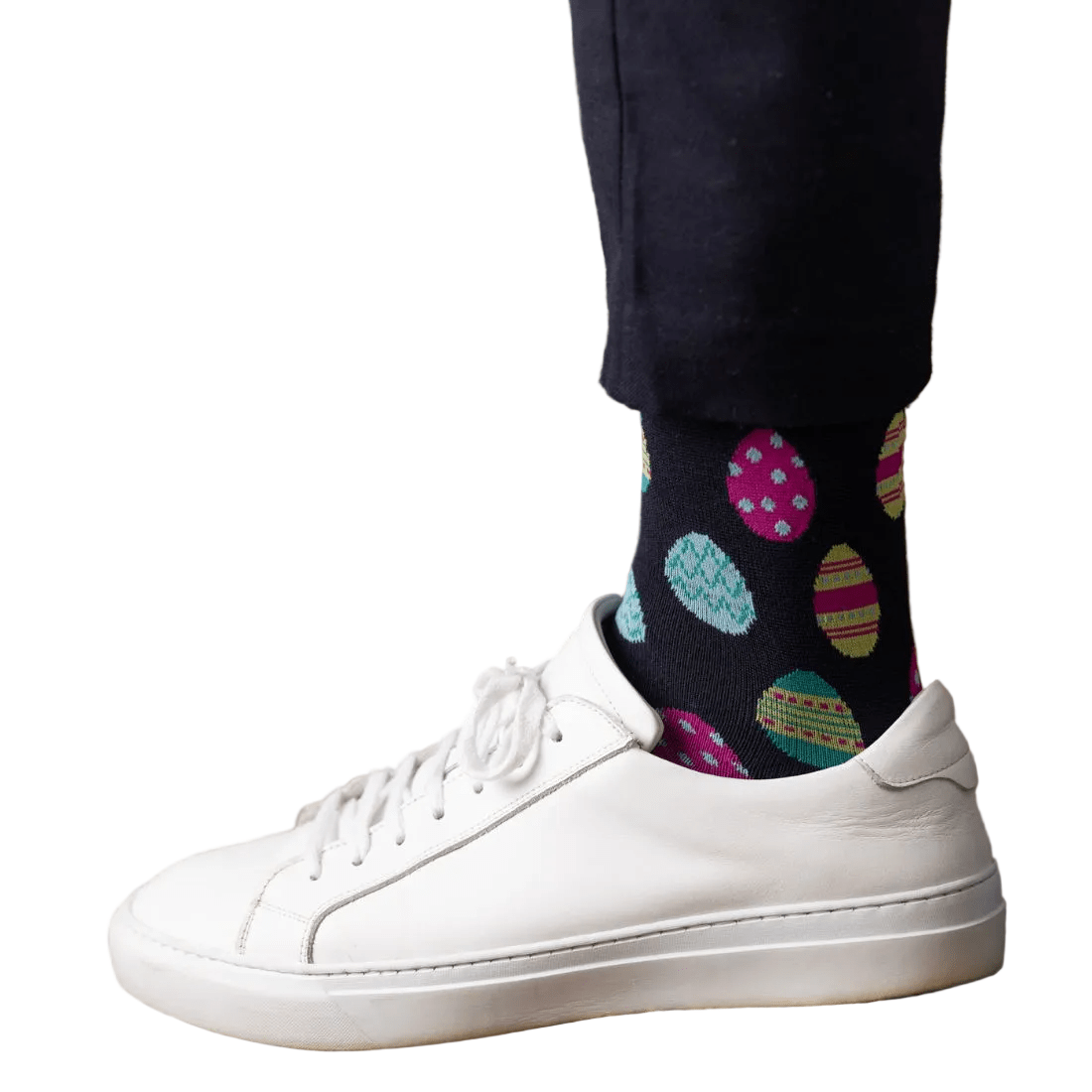 White sneakers with colorful polka dot socks on a woven surface