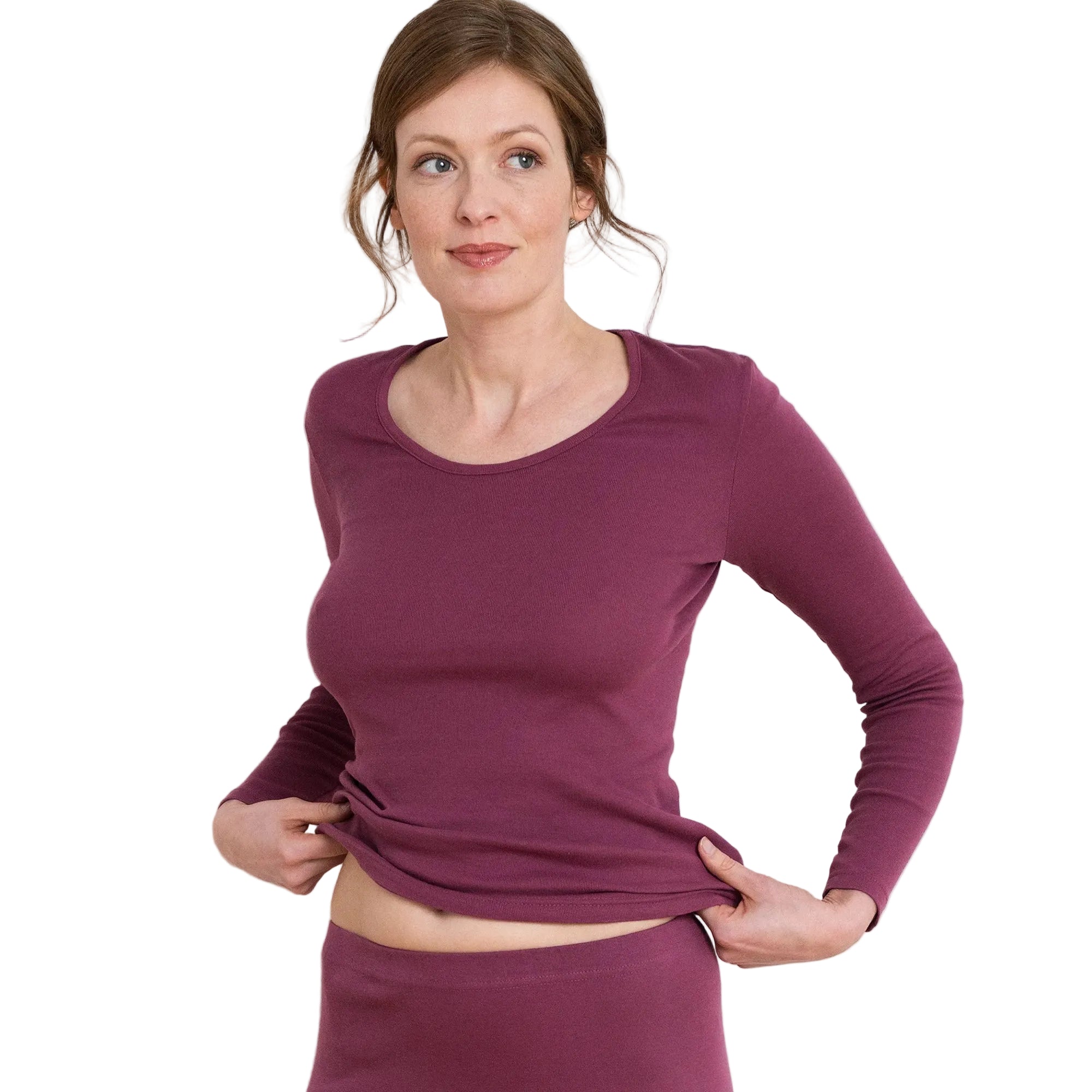 Woman wearing a purple long-sleeve top and leggings against a white background