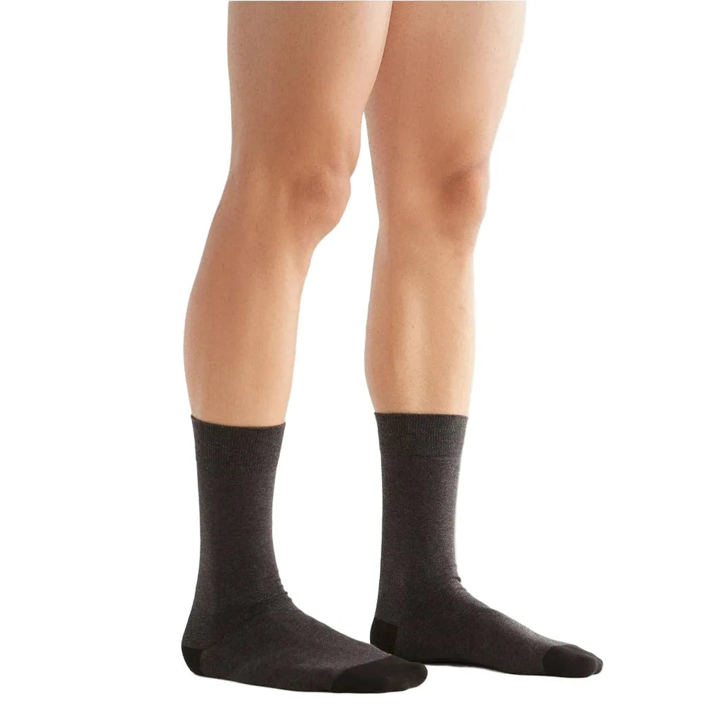 Dark gray socks worn by a person on a white background