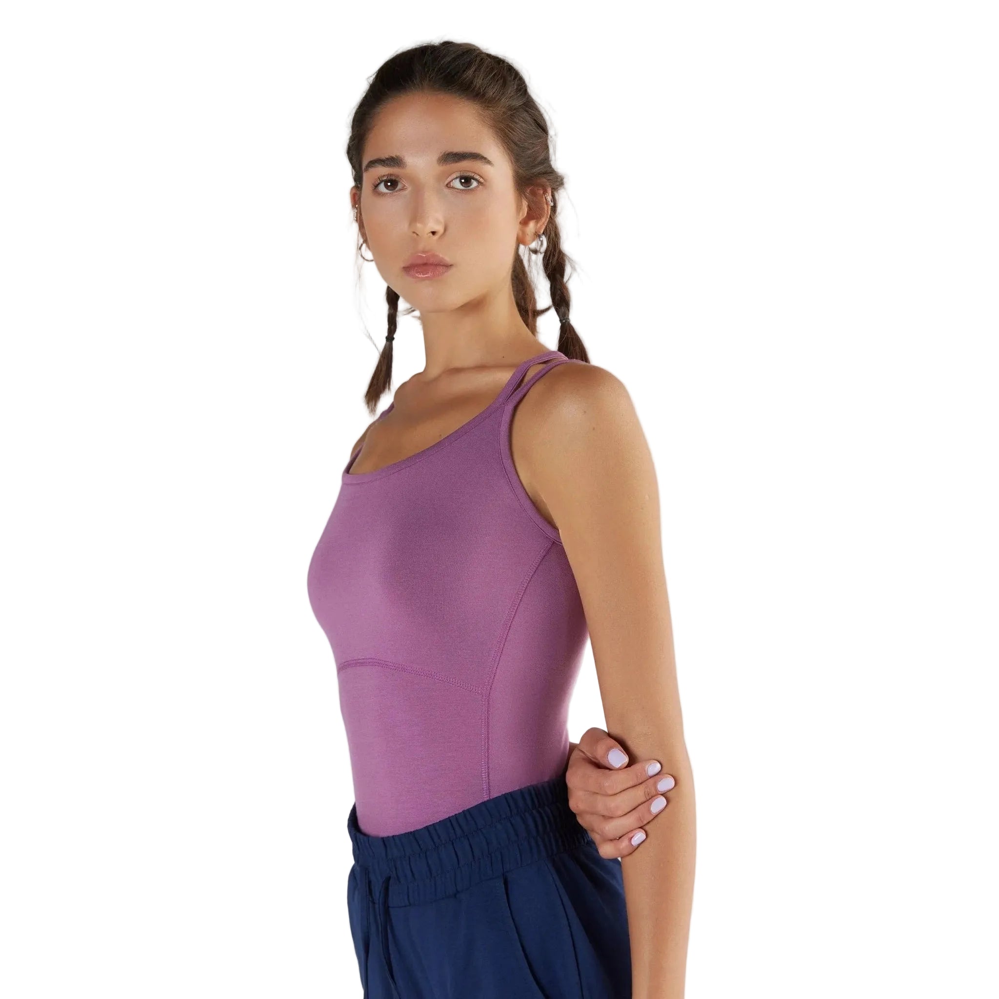 Woman wearing a purple sleeveless top and blue pants on a white background