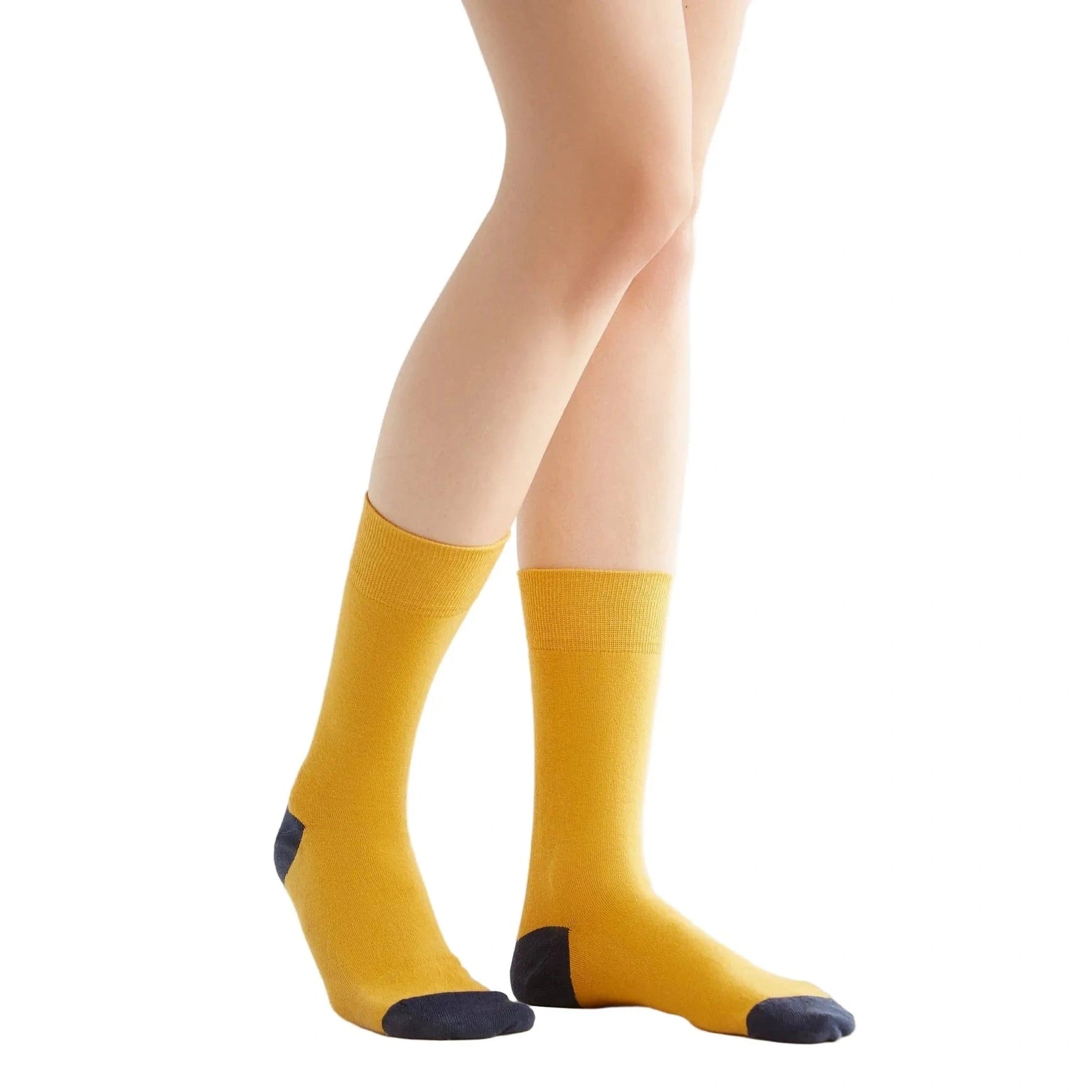 Yellow socks with black toes and heels worn by a person on a white background
