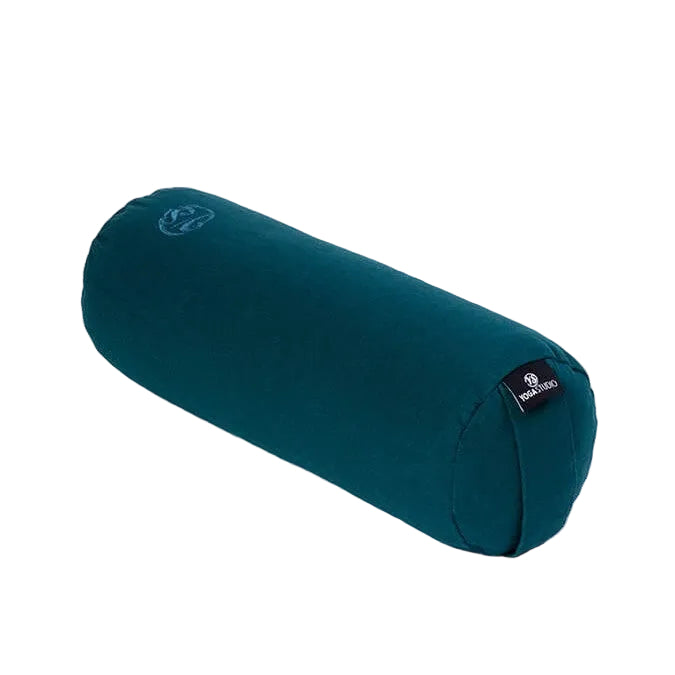 A dark teal yoga bolster pillow with a small black brand tag on one end, shown on a plain white background.
