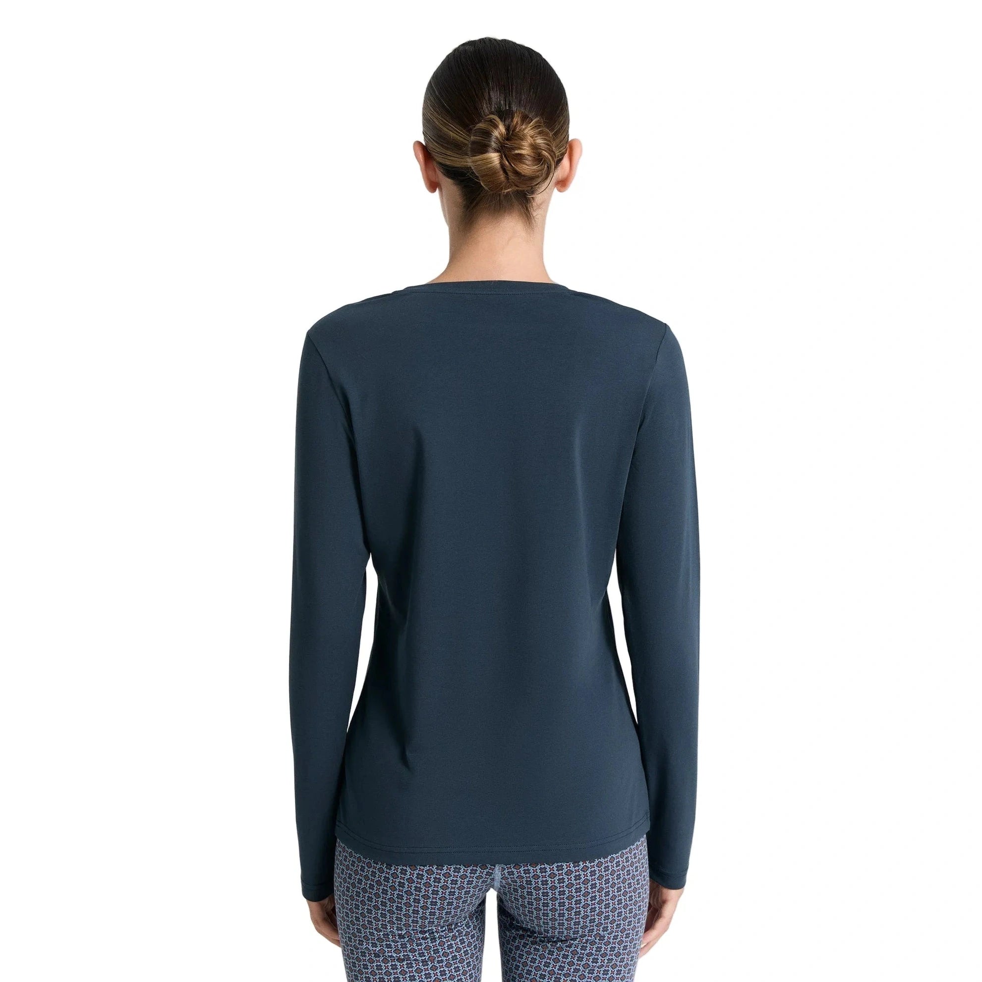 Person wearing a dark blue long-sleeve top on a white background