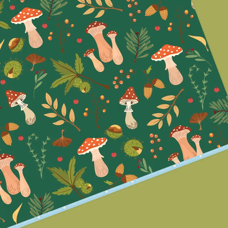 A sheet of Patterned wrapping paper printed with mushrooms and foliage on a green background