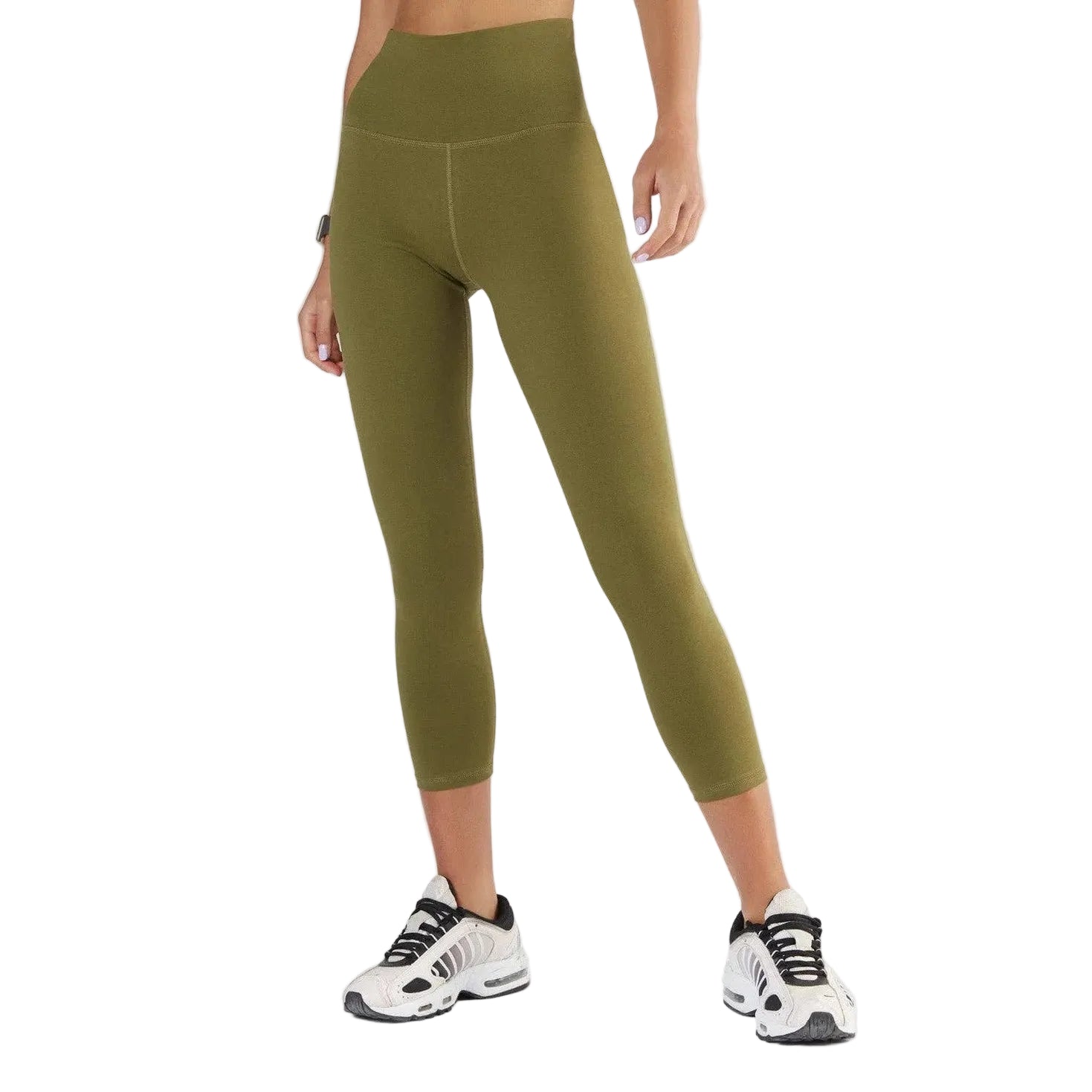 Person wearing green leggings and white sneakers on a white background