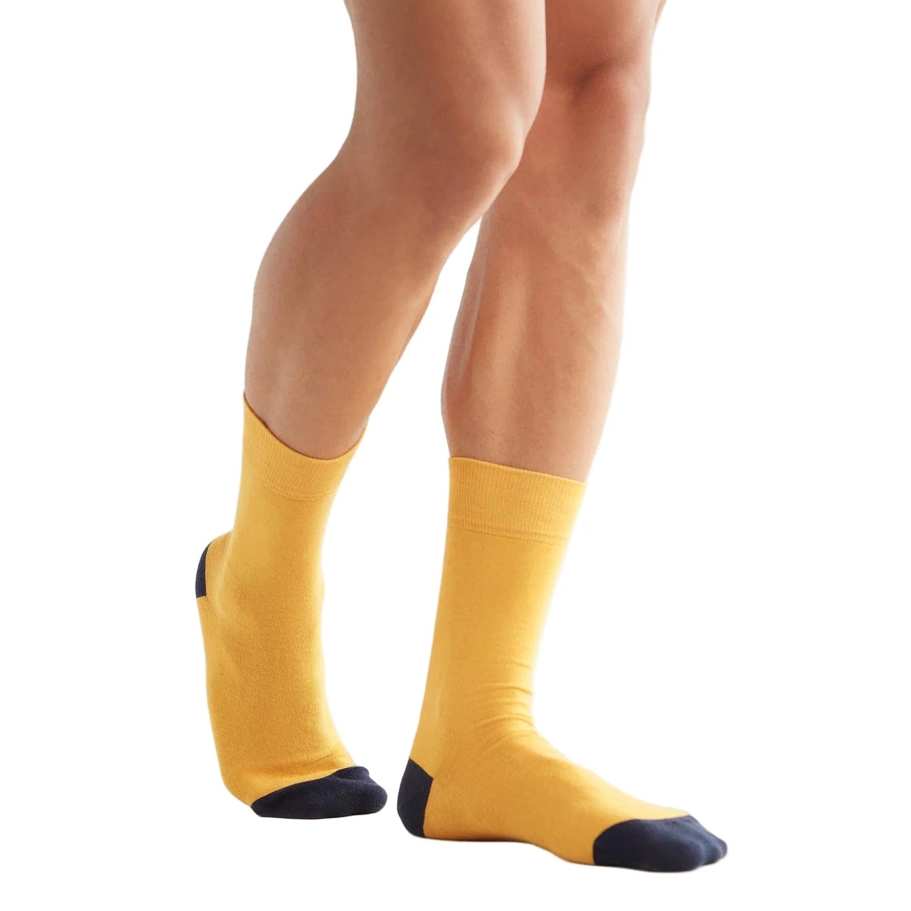 Yellow socks with black toes and heels worn by a person on a white background