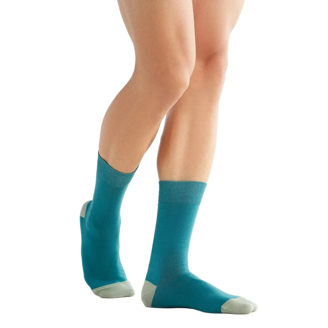 Teal socks worn by a person on a white background