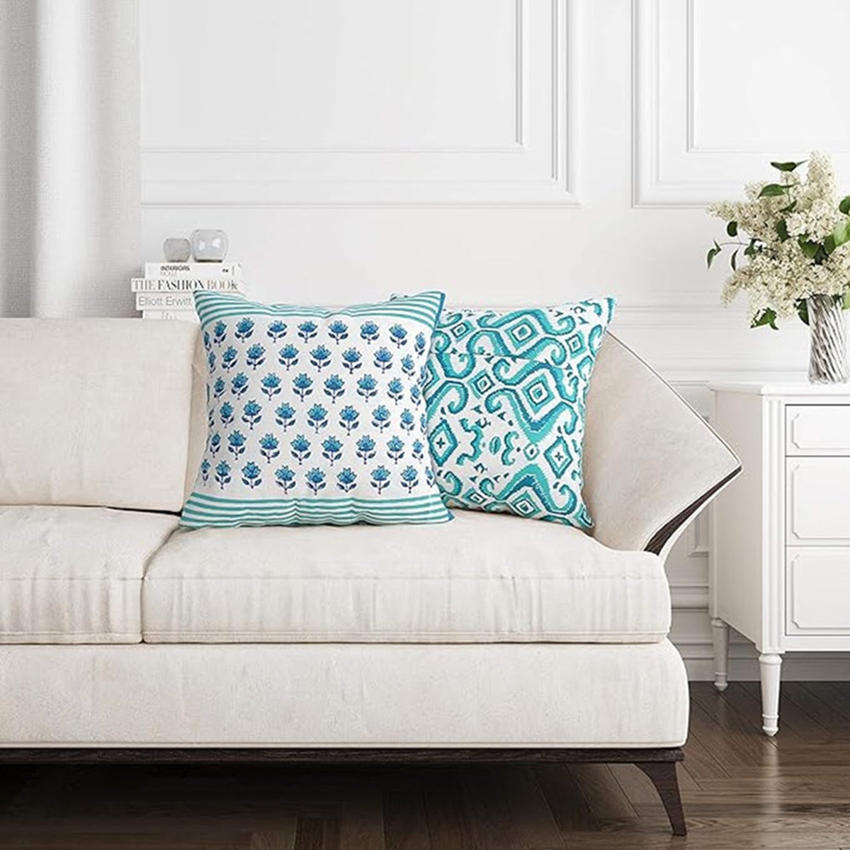 White sofa with decorative pillows featuring blue patterns in a living room setting.