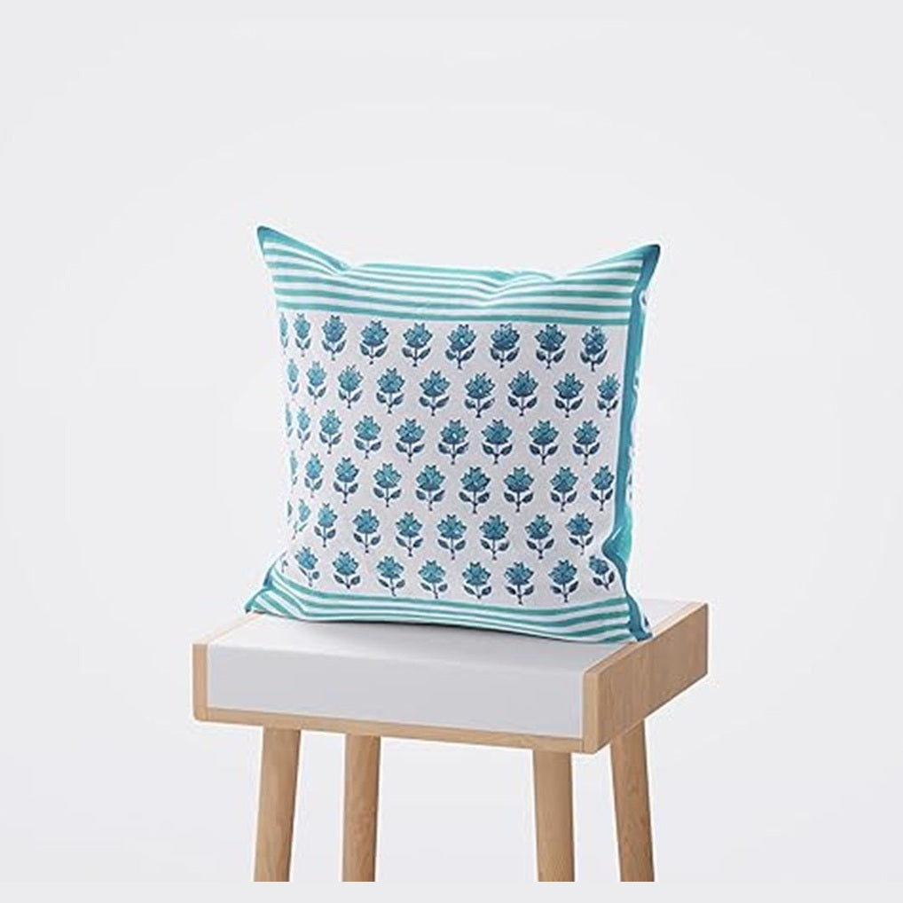 Decorative pillow with floral pattern on a small wooden stool against a white background