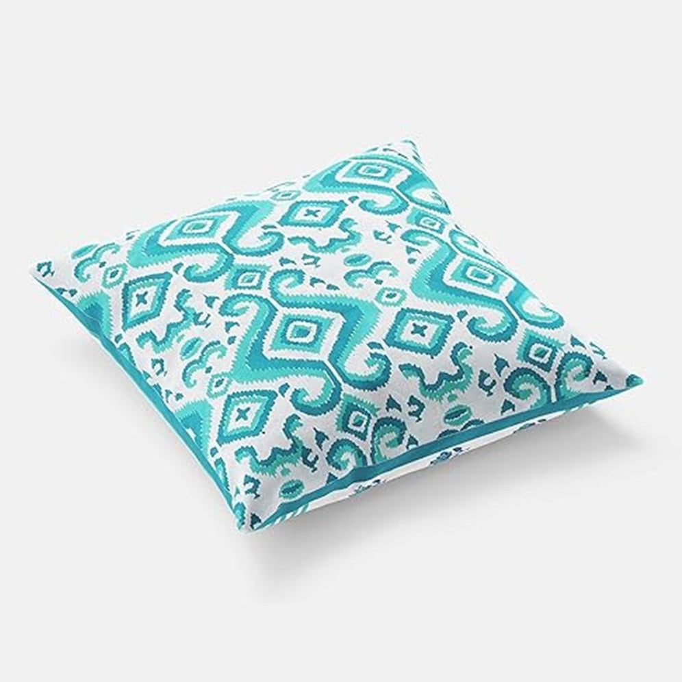 Turquoise patterned pillow on a white background