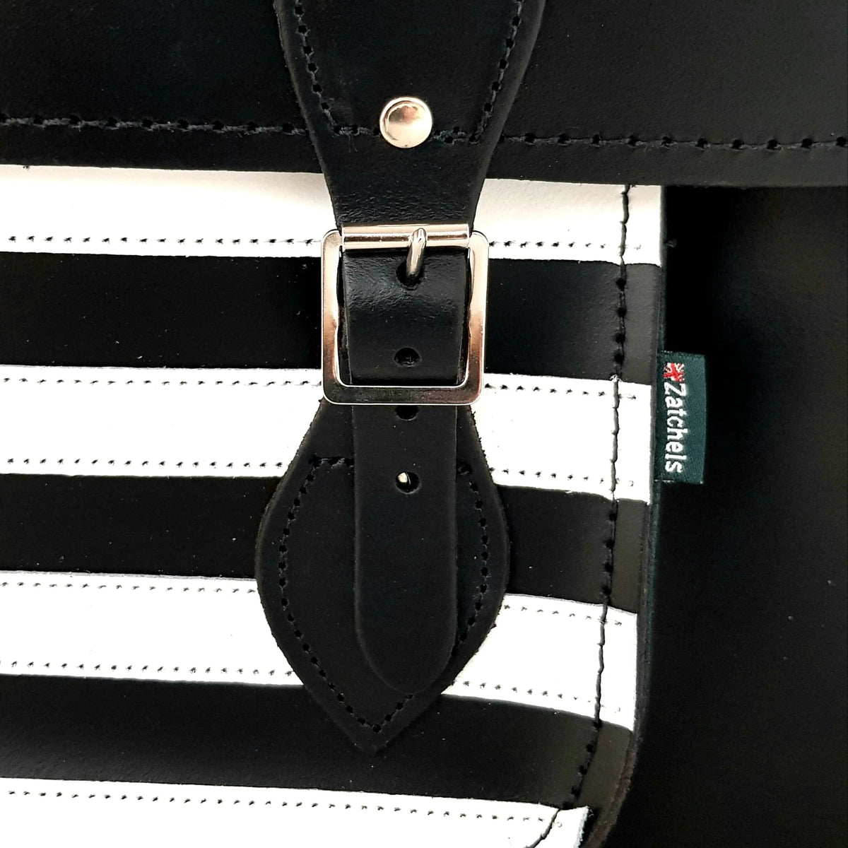 Close-up of the buckle, stitching and Zatchels label on the Gothic striped leather satchel.