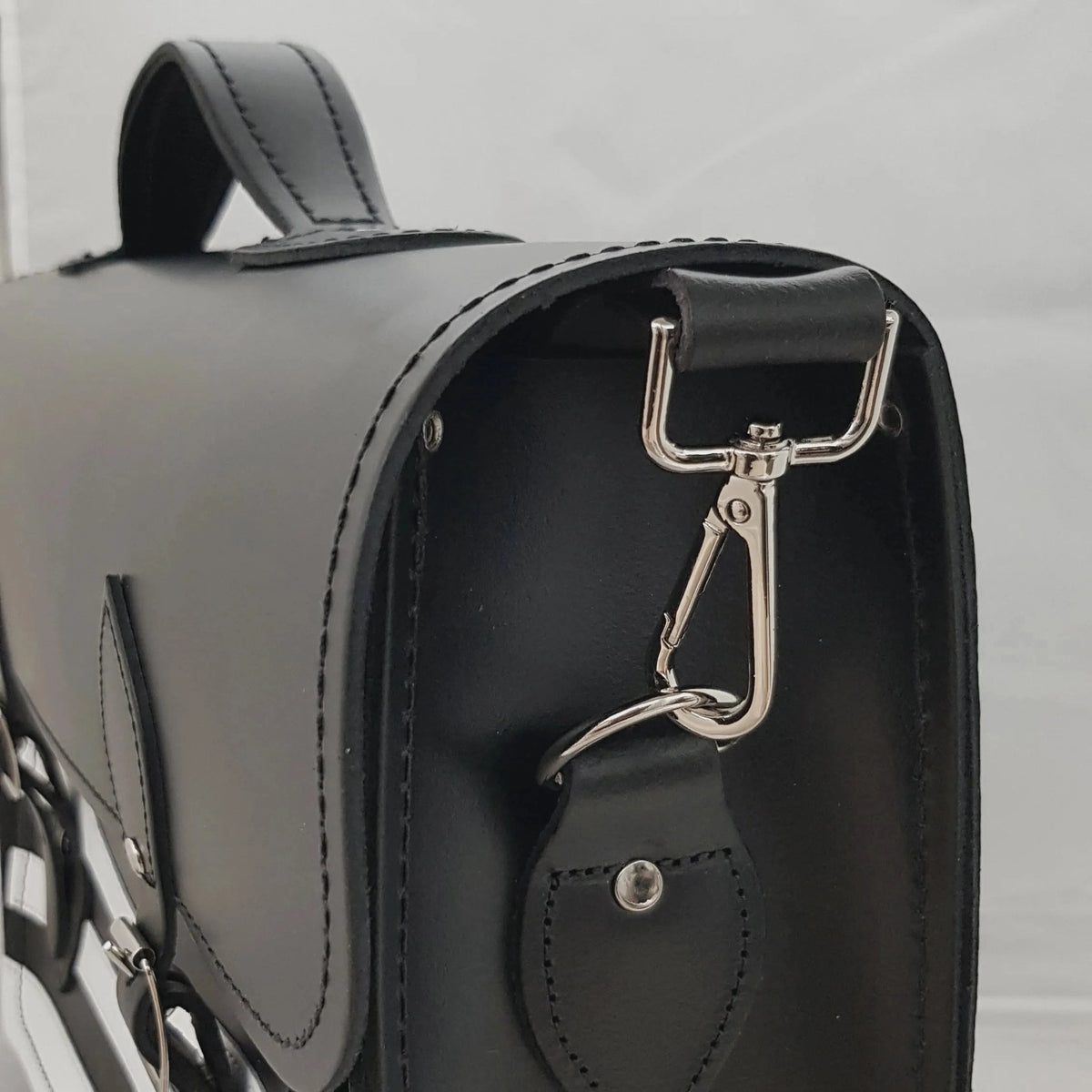 Close-up of the detachable shoulder strap clip on the black leather Gothic satchel