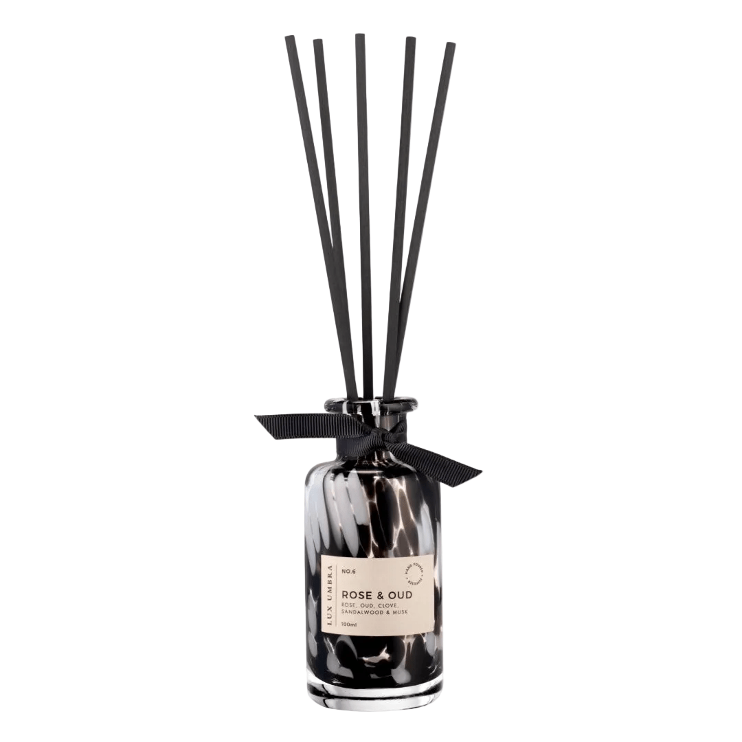 Diffuser with black reeds and a label on a white background