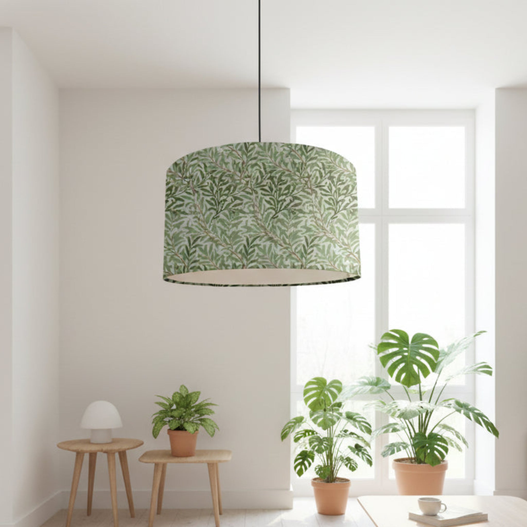 Green leaf-patterned lampshade in a room with plants and a window.