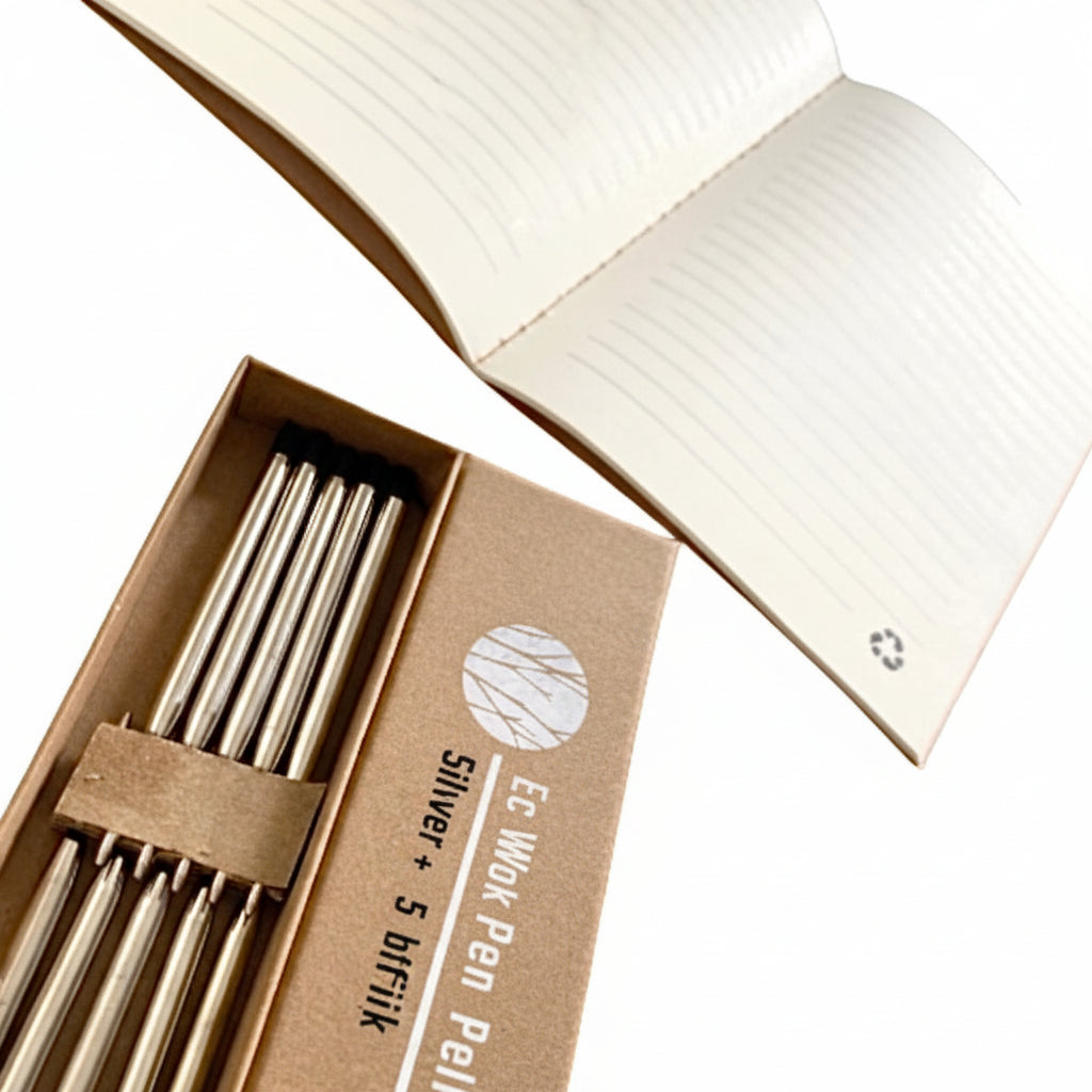 Set of silver pens in a cardboard box with a notebook in the background