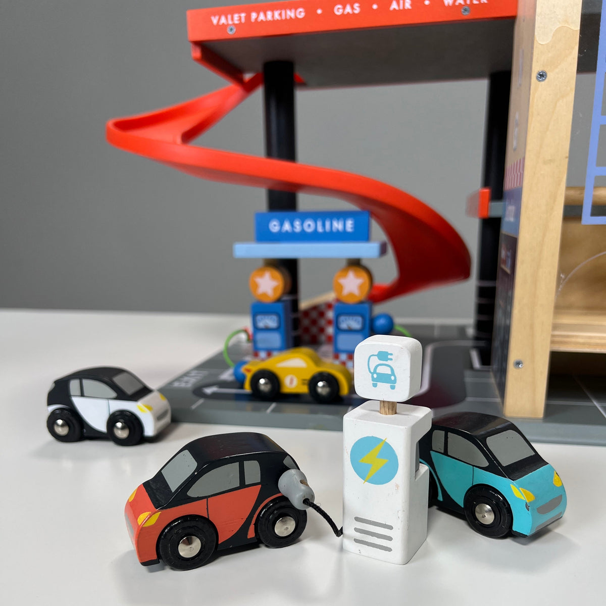Smart Car Set cars and pretend charger with a toy garage in the background