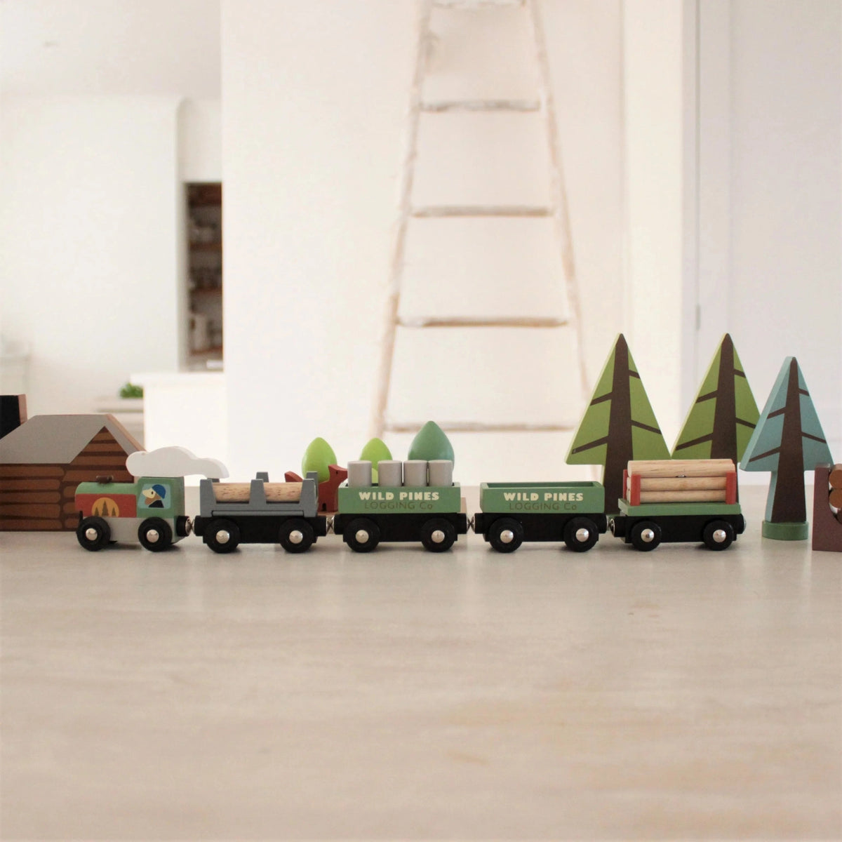 Wooden toy train set with trees on a wooden floor