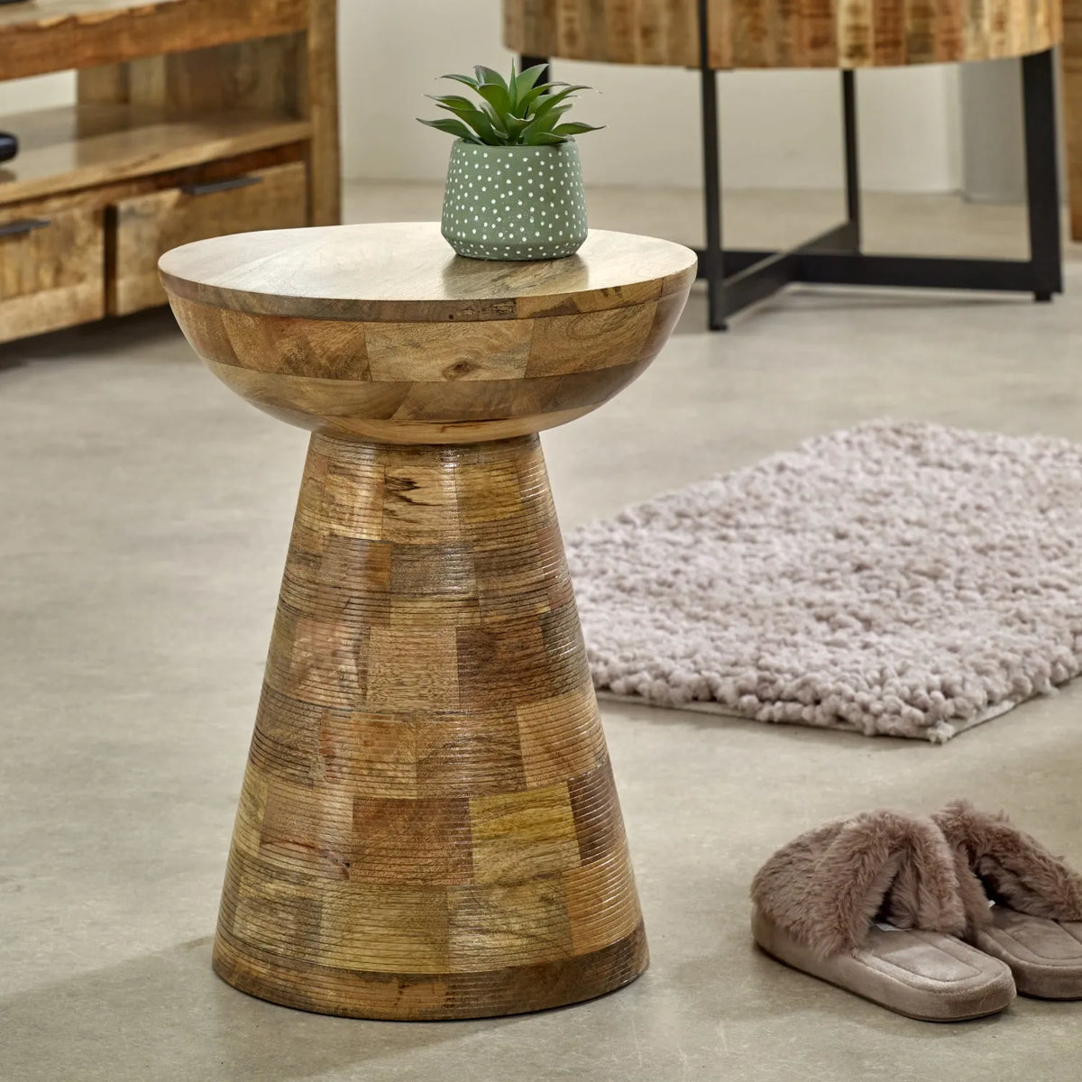 Wooden side table with a plant on a concrete floor