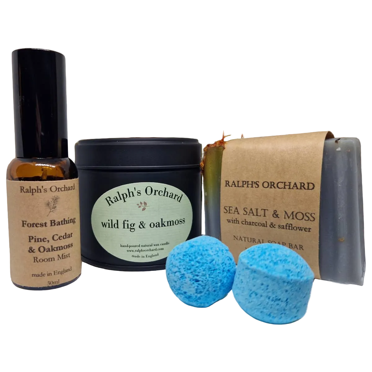 A bath and room set from Ralph's Orchard on a white background, featuring a Forest Bathing room mist bottle, a Wild Fig & Oakmoss candle, a Sea Salt & Moss soap bar, and two blue bath bombs.