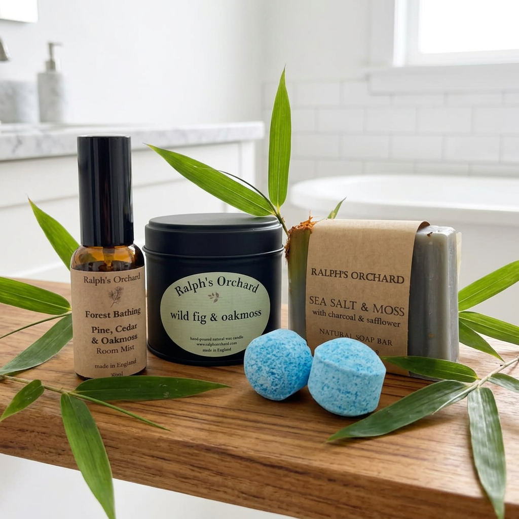 Ralph’s Orchard candle, Forest Bathing room mist, Sea Salt & Moss soap and two blue bath bombs on a wooden board in a bright bathroom.