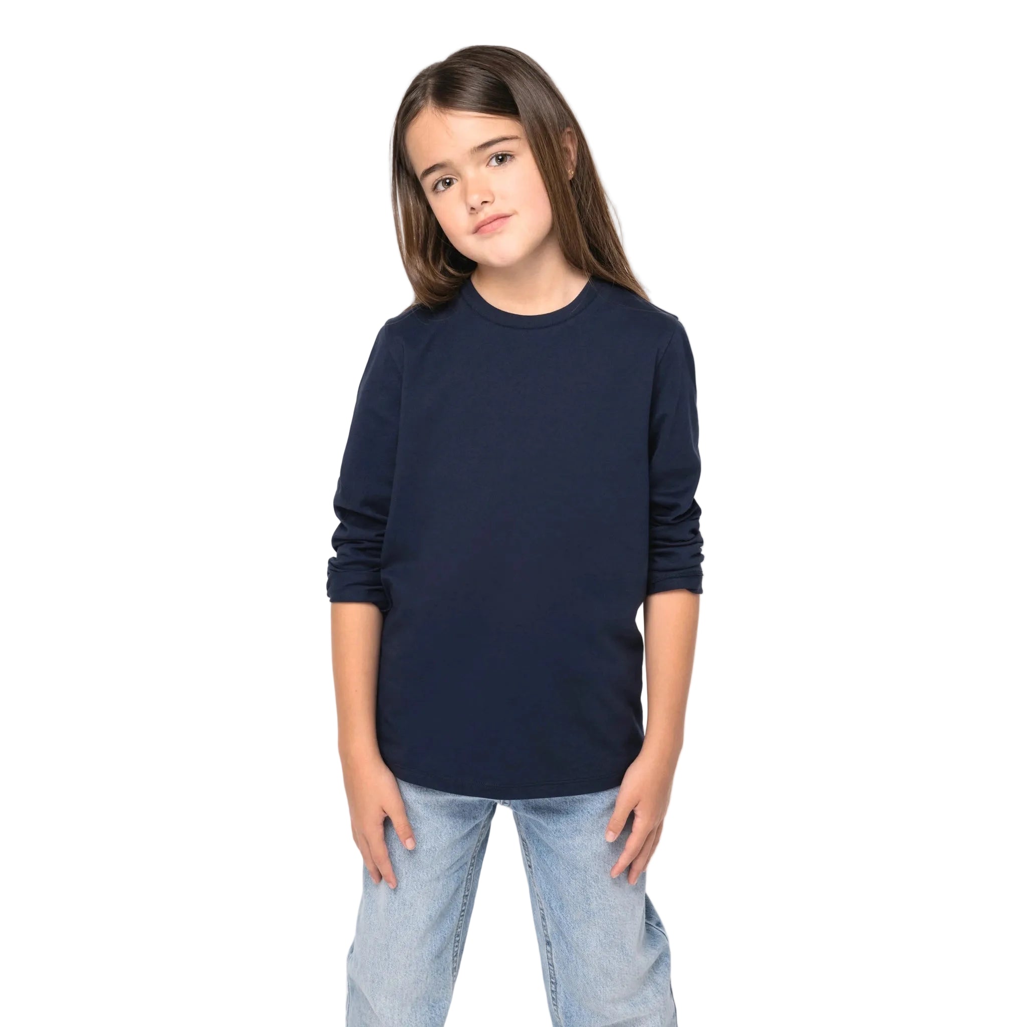 Young girl wearing a navy blue organic long-sleeved T-shirt and light blue jeans on a white background