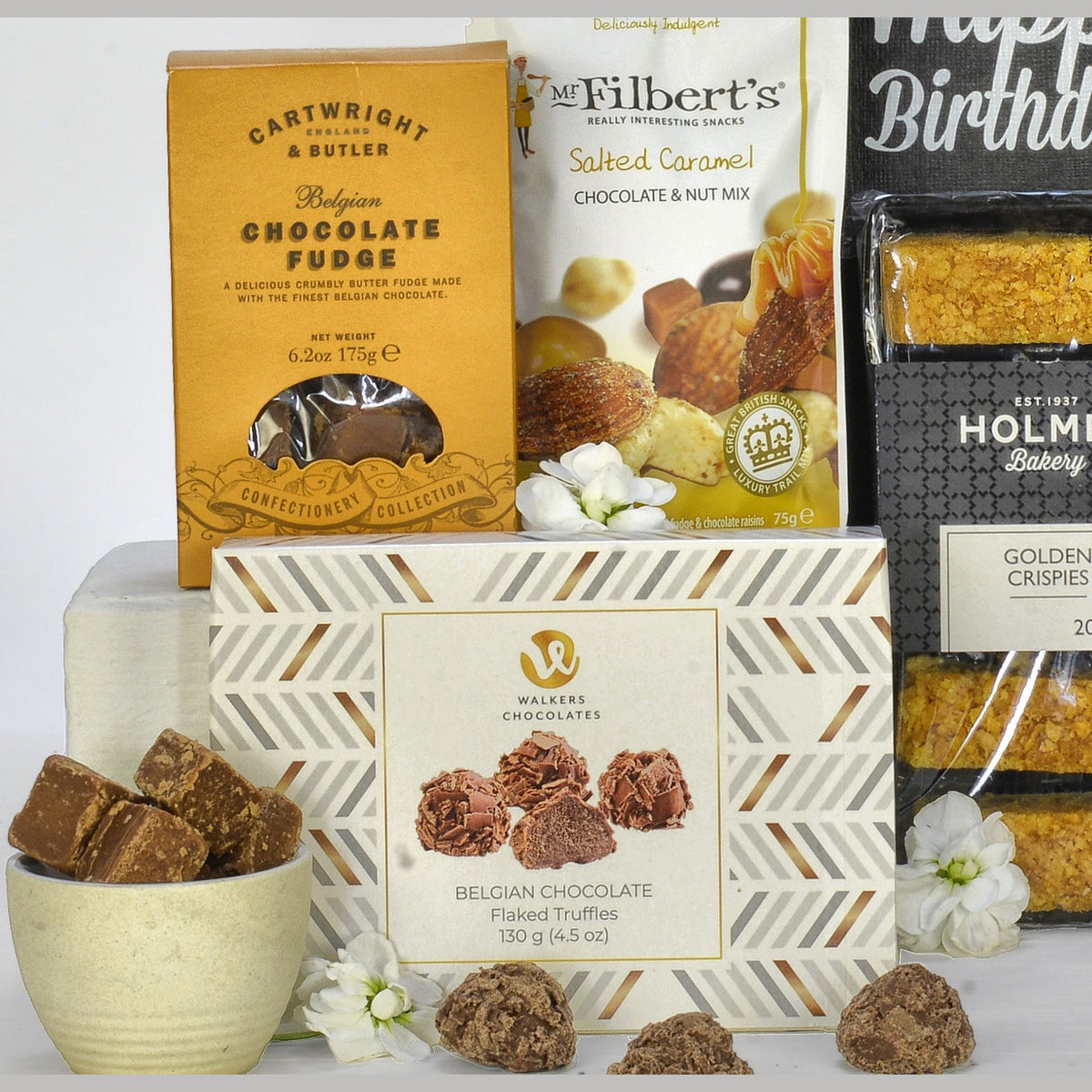 Assorted gourmet chocolate and bakery items on a white background