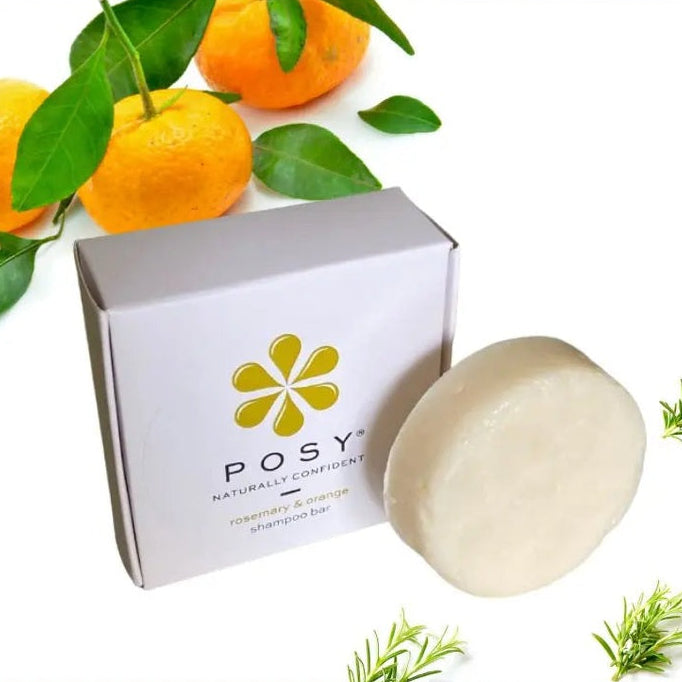 Posy shampoo bar with packaging and oranges on a white background