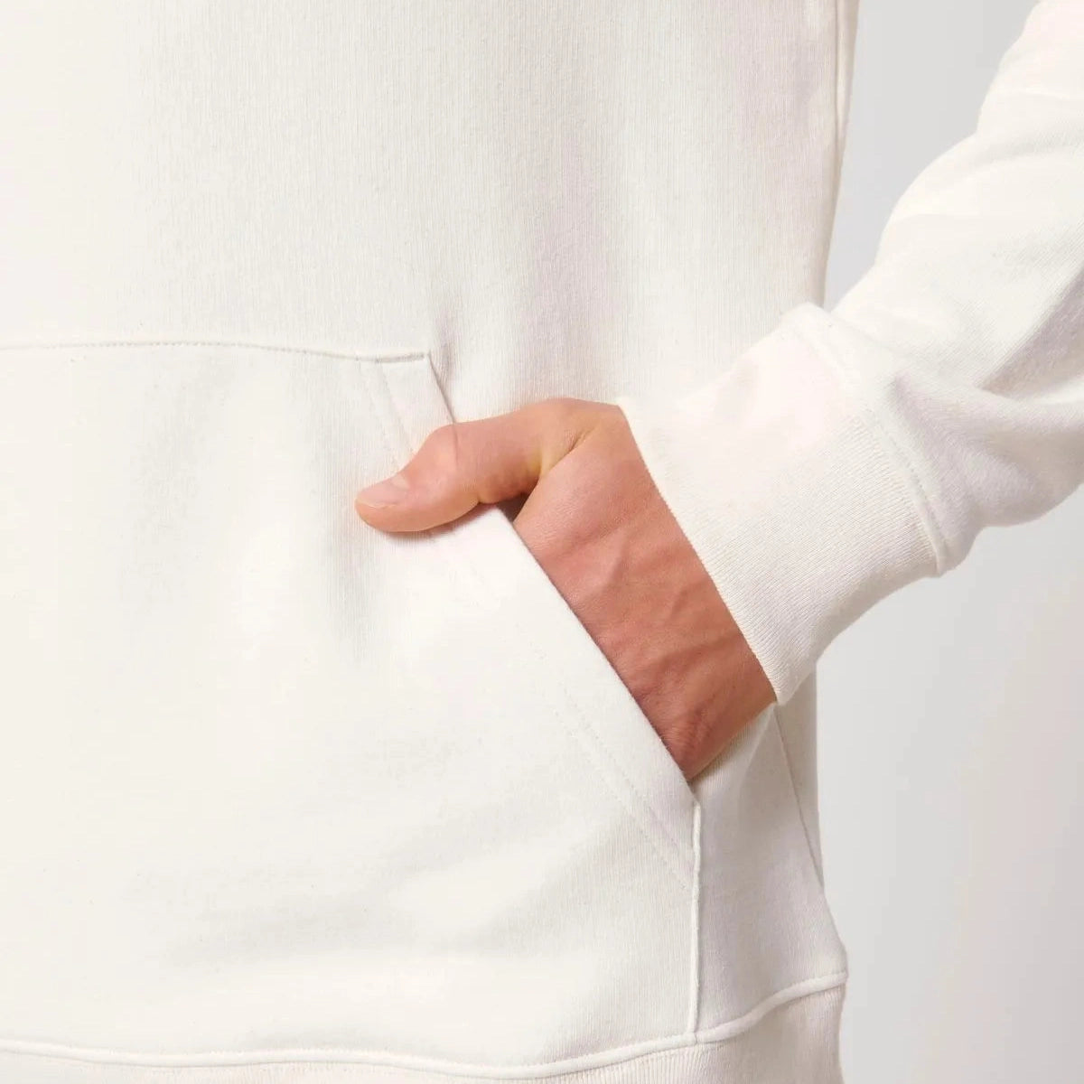 White hoodie with a hand in the pocket against a light gray background