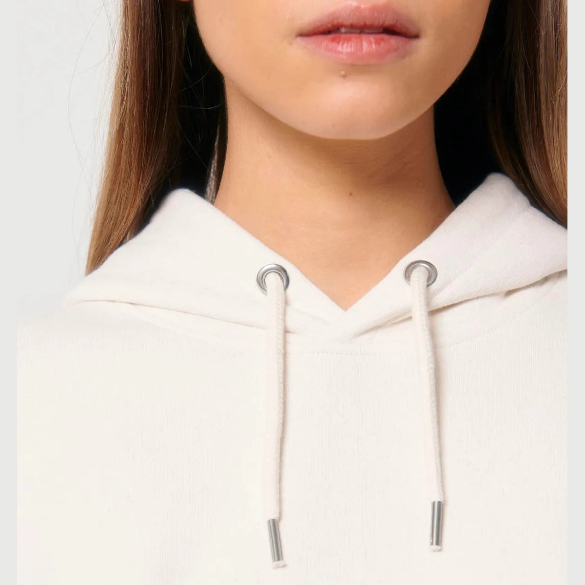 Close-up of a person wearing a white hoodie with a blurred background