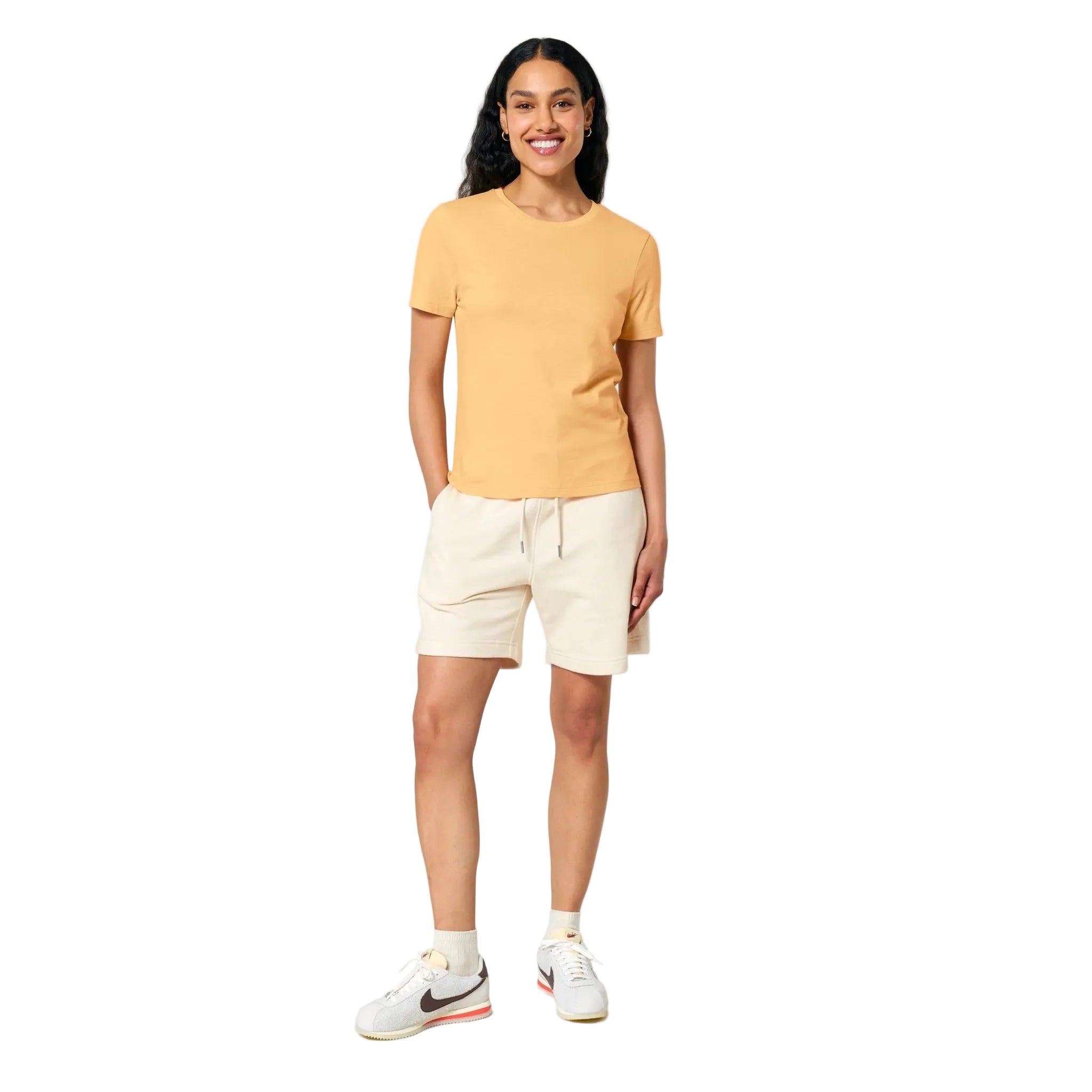 Woman wearing a yellow t-shirt and beige shorts on a white background
