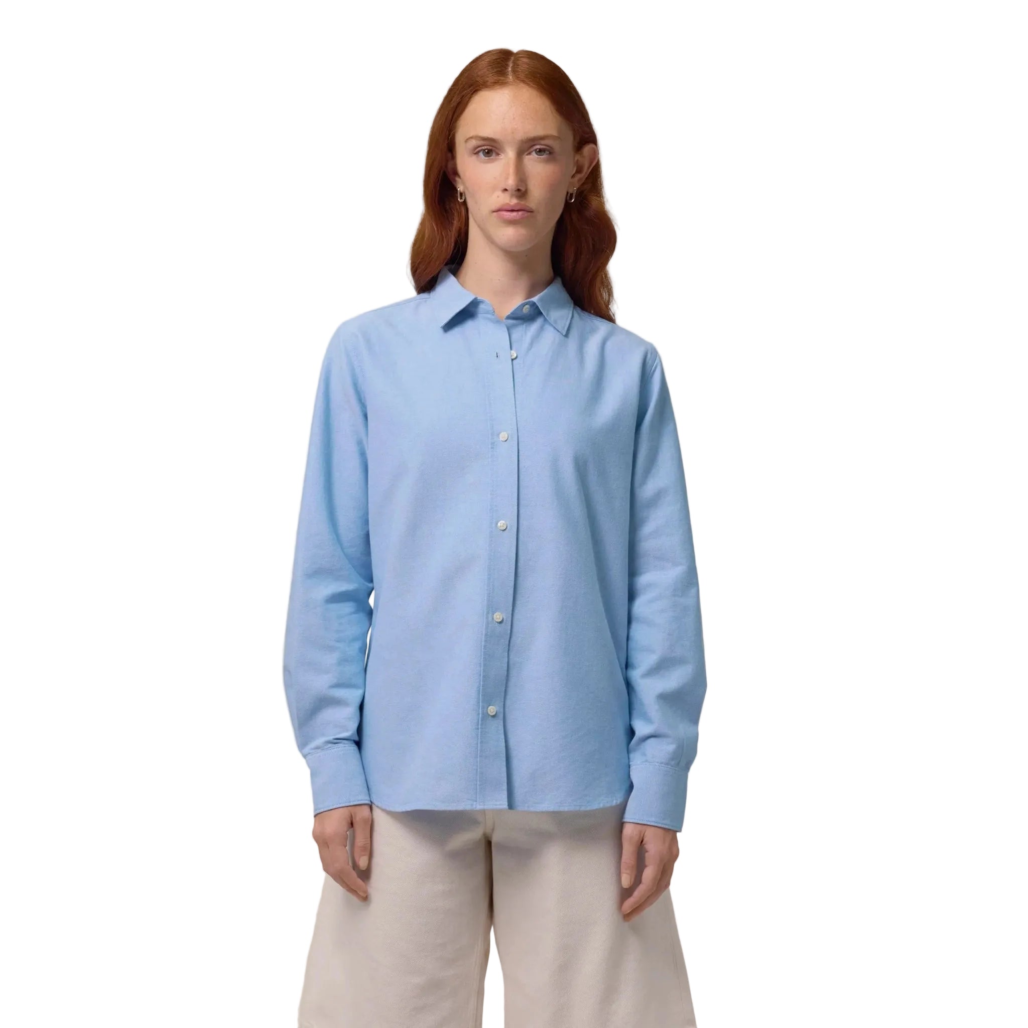 Woman wearing a light blue button-up shirt on a white background