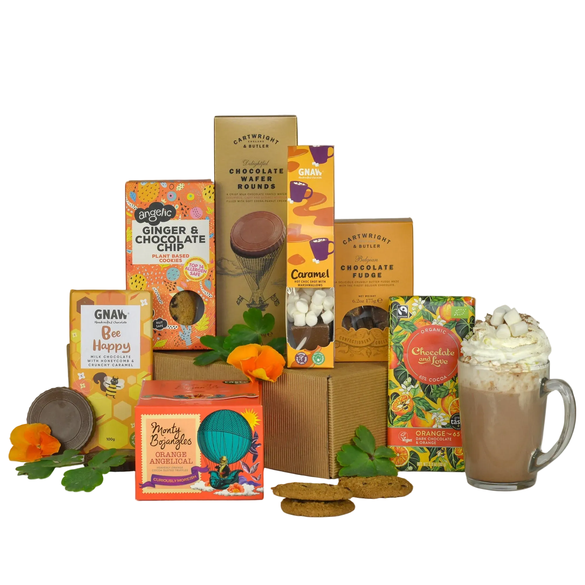 A curated gift assortment of sustainable gourmet chocolates, cookies, and a chocolate milk mug arranged on a white background. Visible brands include Organic, Gnan, and Pretty Big Boxes.