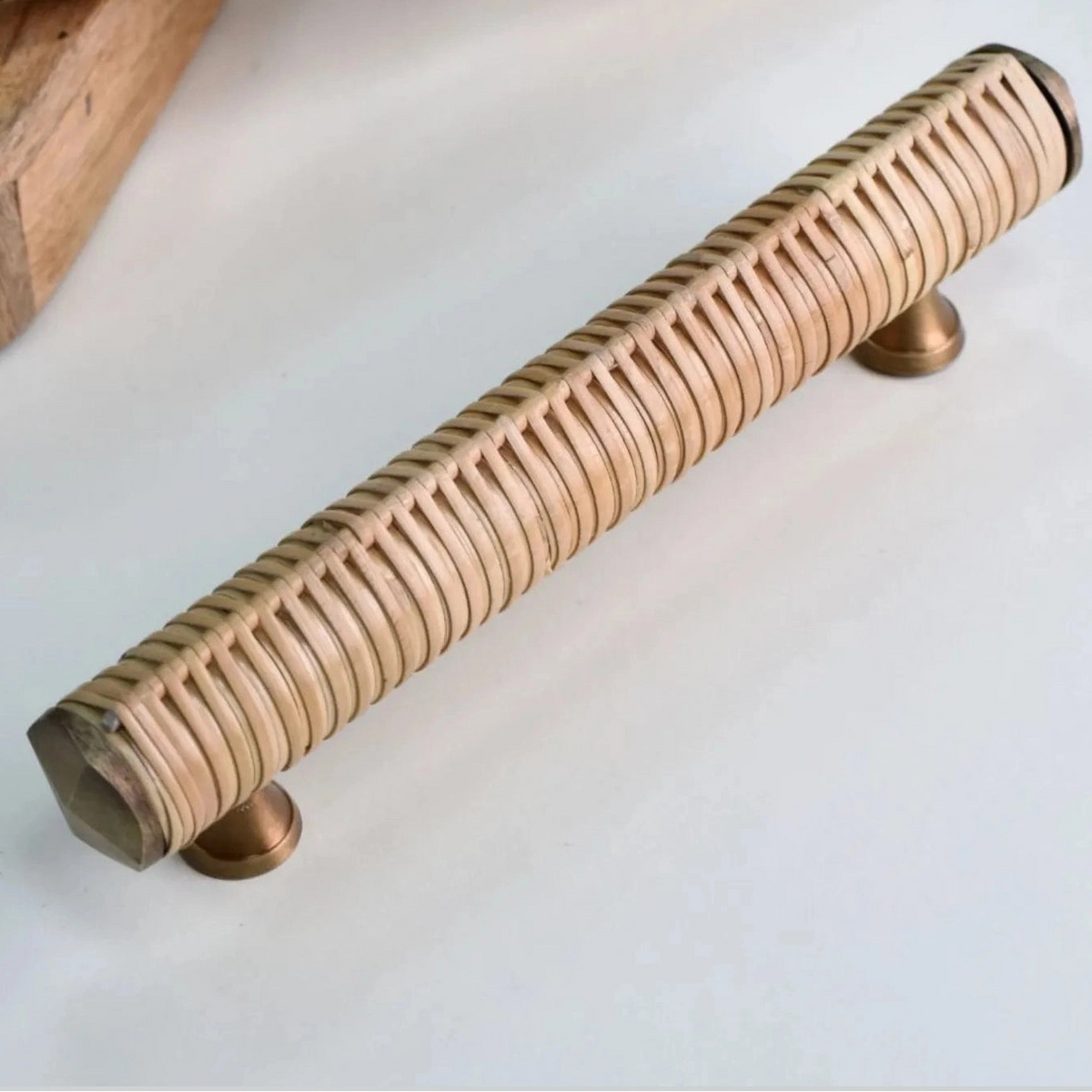 Druridge rattan bar handle showing its woven surface, metal end caps and mounting feet
