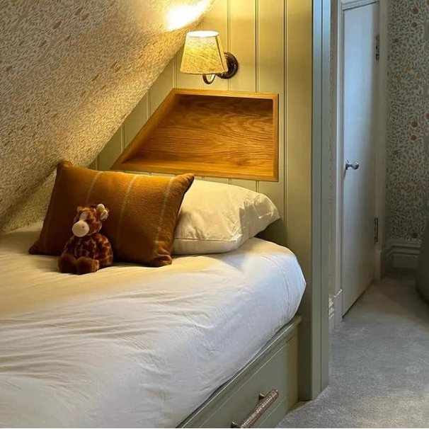 Dunstanburgh rattan bar handle fitted to a pale green storage drawer beneath a bed
