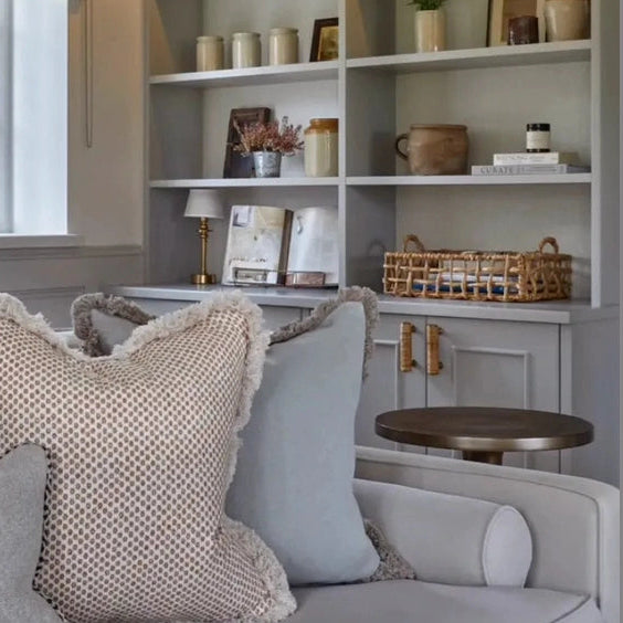 Dunstanburgh rattan handles on a pale built-in cabinet beneath open shelving
