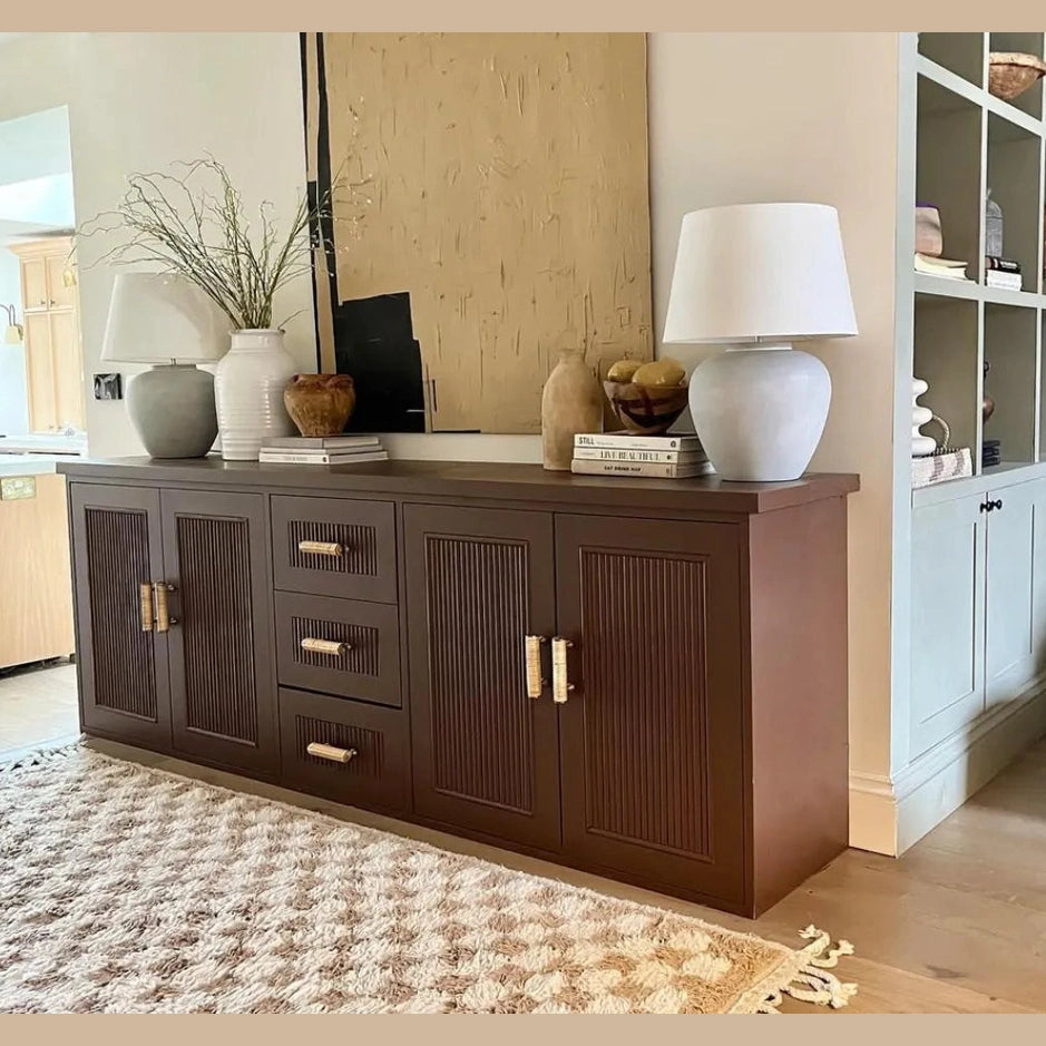 Dunstanburgh rattan handles fitted to the drawers and doors of a dark brown sideboard