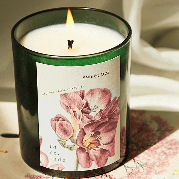 Sweet pea soy wax candle with a floral label on a table