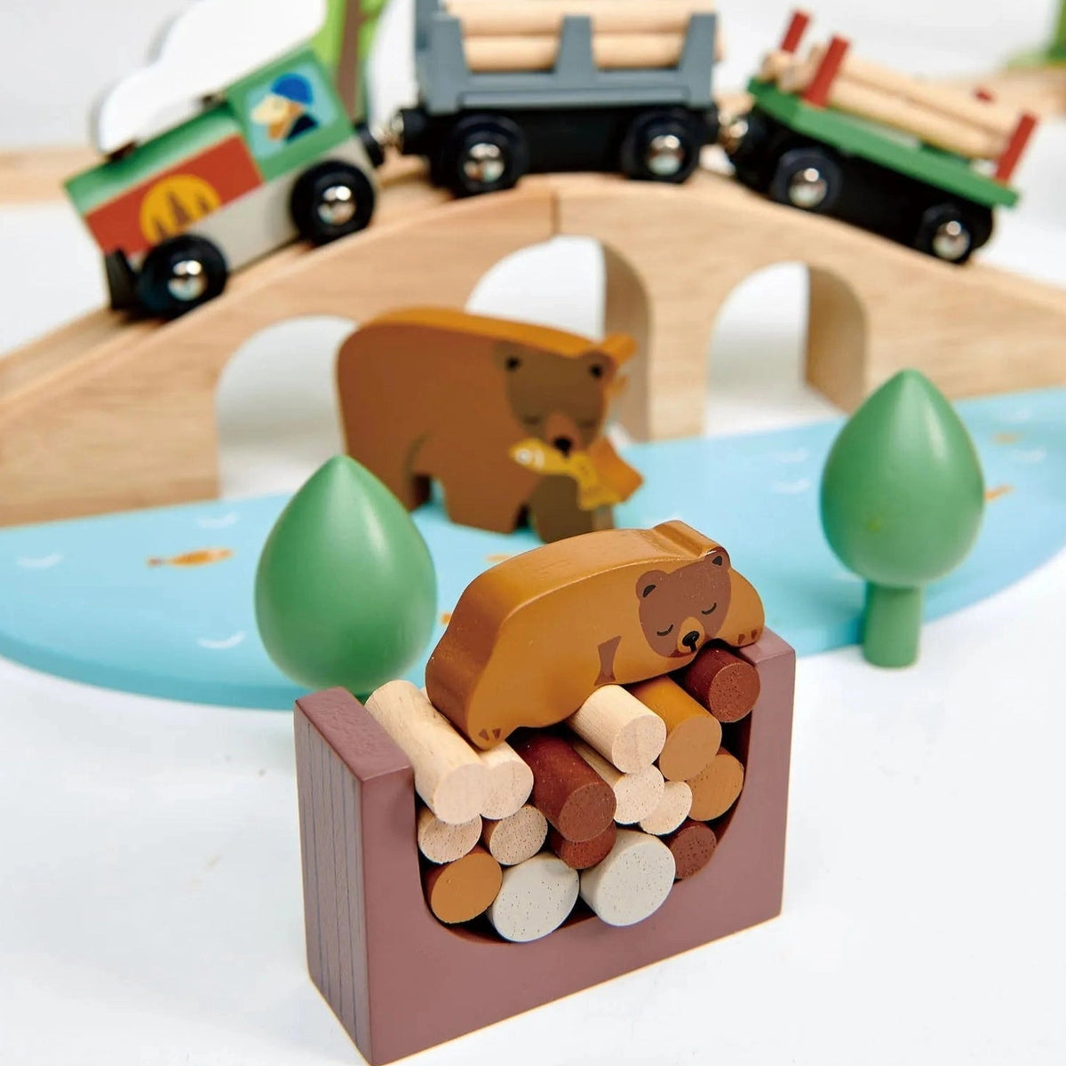Wooden toy train set with bears and trees on a white background