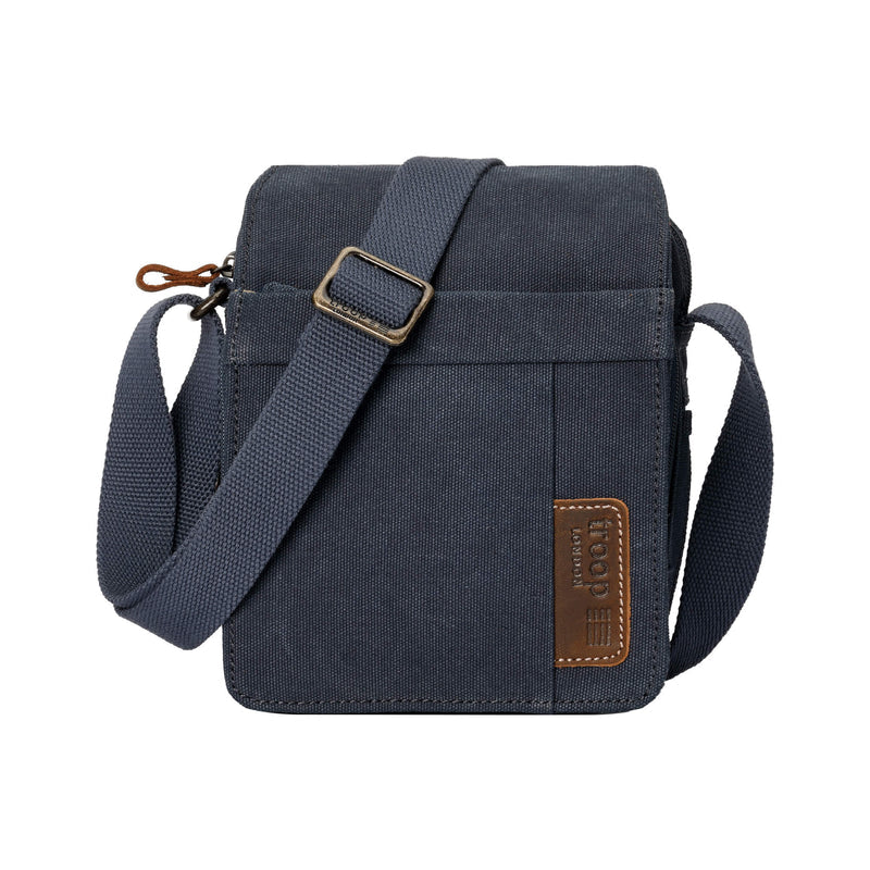 Denim-blue Troop London canvas crossbody bag with a matching adjustable strap and brown brand patch on a white background