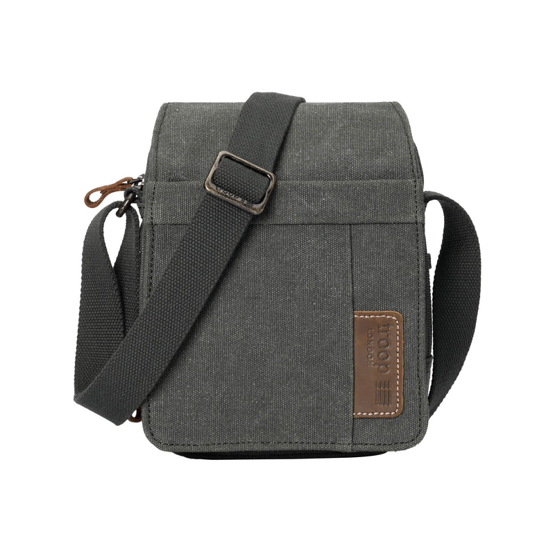 A dark green Troop London shoulder bag with a brown patch on a white background