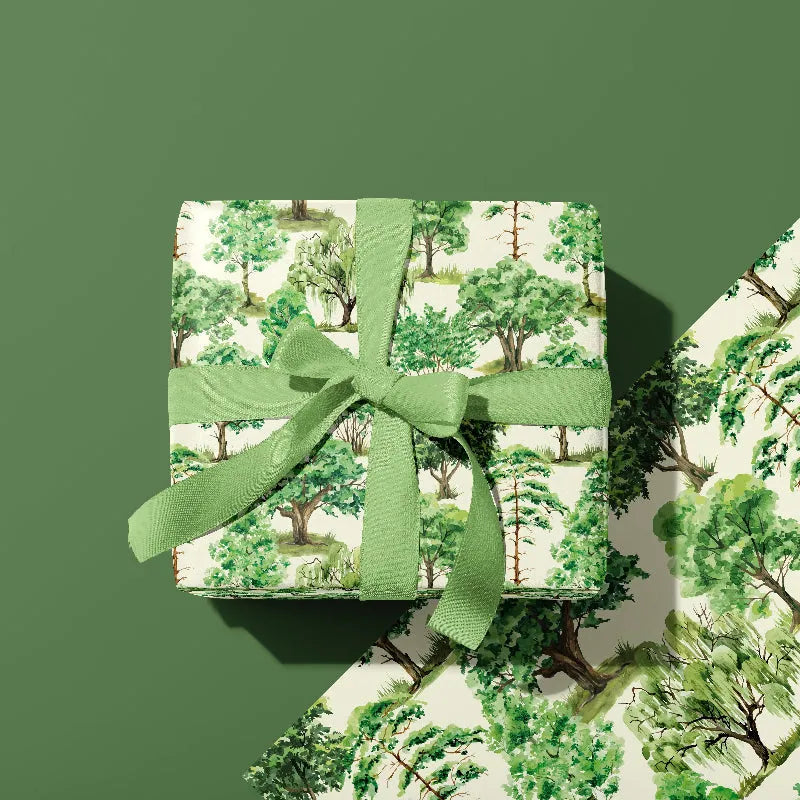 Gift wrap with green ribbon on a green background with a tree pattern